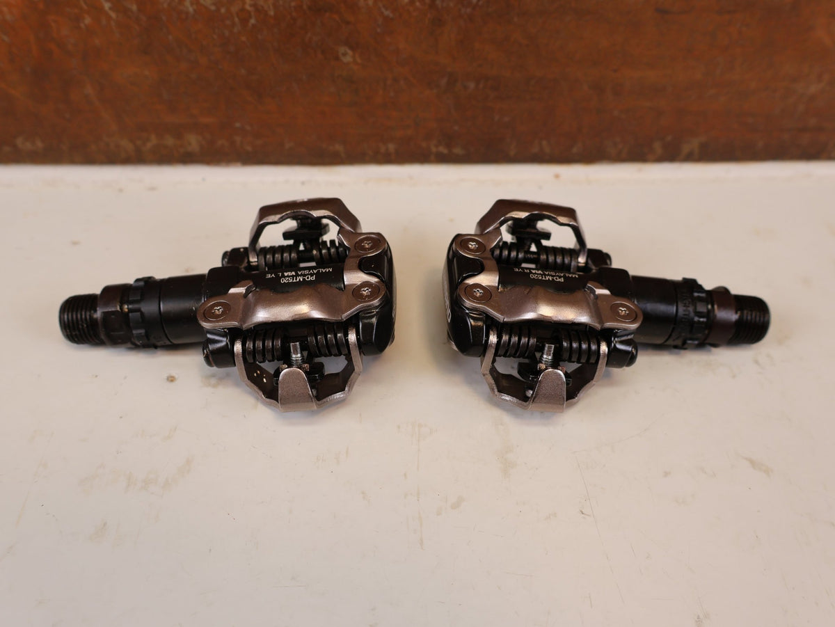 Pedale von Shimano, SHIMANO PD MT520 BEIDSEITIGE SPD KLICKPEDALE SCHWARZ vor USEDBIKES-OB.DE Hintergrund