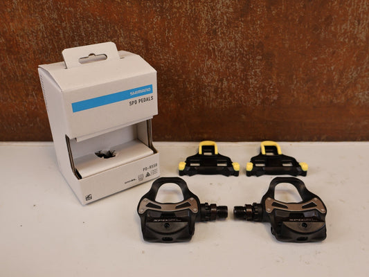 Pedale von Shimano, SHIMANO PD R550 COMPOSITE SPD SL RENNRAD PEDALE vor USEDBIKES-OB.DE Hintergrund