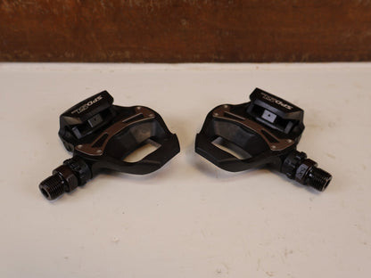 Pedale von Shimano, SHIMANO PD R550 COMPOSITE SPD SL RENNRAD PEDALE vor USEDBIKES-OB.DE Hintergrund