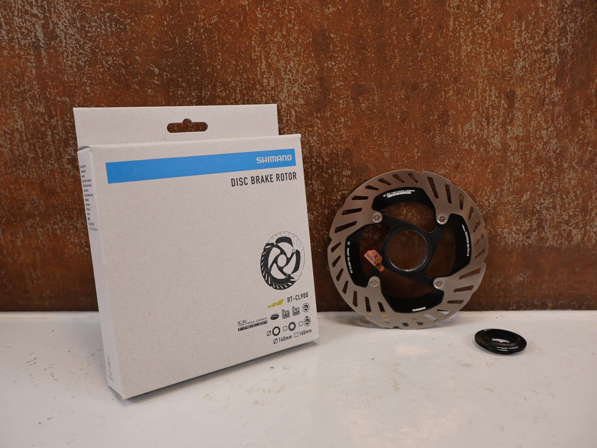 Bremsscheibe von Shimano, Shimano RT-CL900 Center Lock Bremsscheibe 140mm IRTCL900SSI vor USEDBIKES-OB.DE Hintergrund