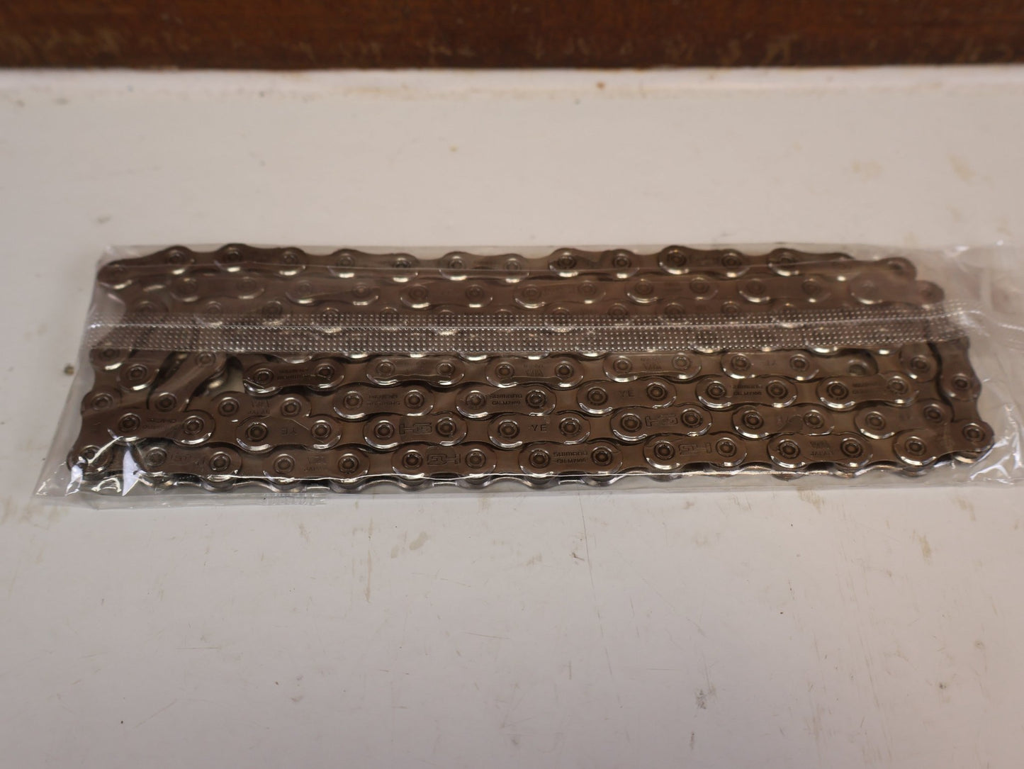 Kette von Shimano, SHIMANO SLX 105 CN M7100 12 FACH KETTE 116 / 126 GLIEDER vor USEDBIKES-OB.DE Hintergrund