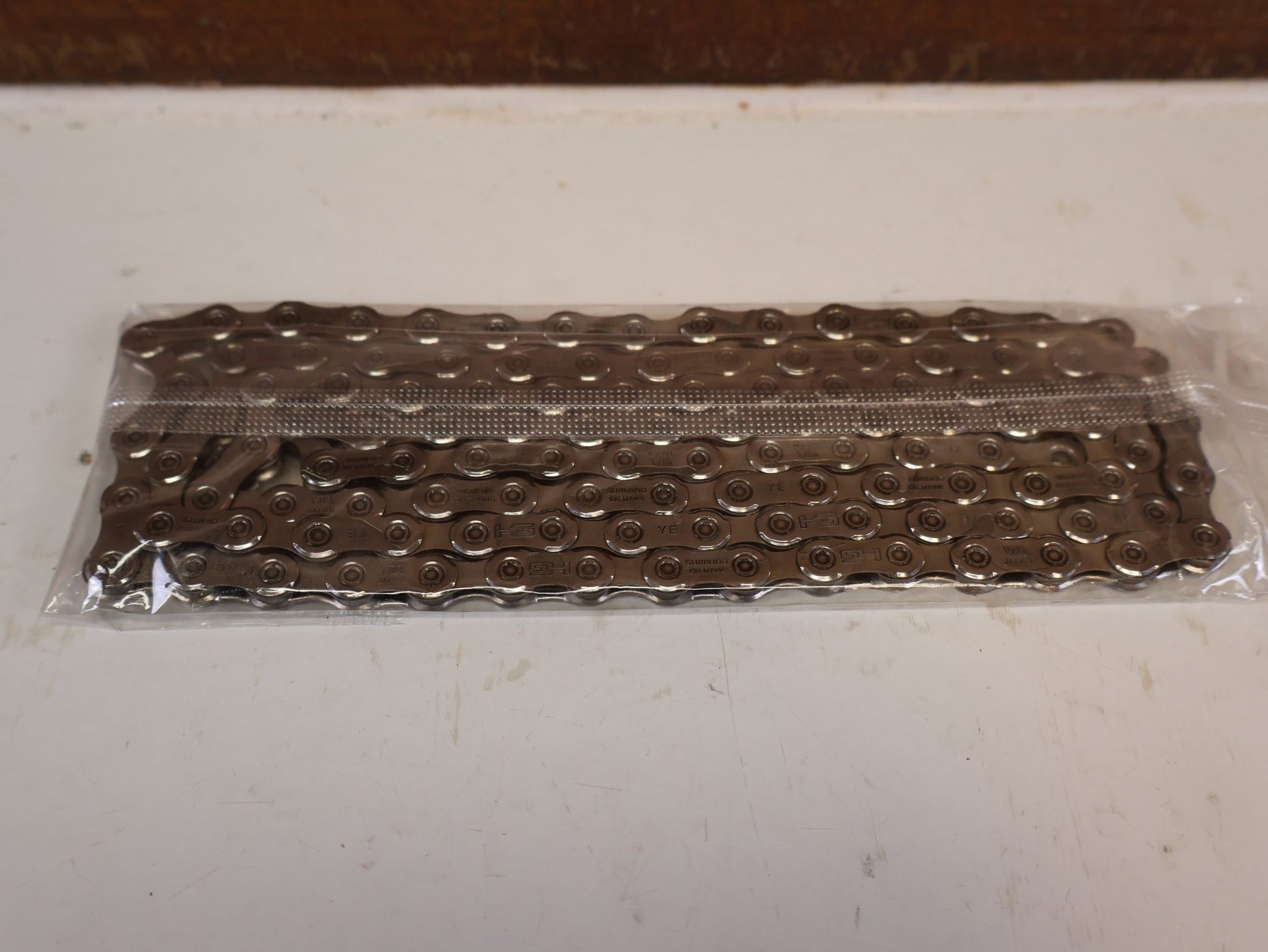 Kette von Shimano, SHIMANO SLX 105 CN M7100 12 FACH KETTE 116 / 126 GLIEDER vor USEDBIKES-OB.DE Hintergrund