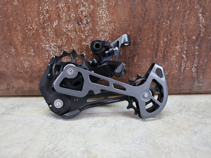 Schaltungsteile von Shimano, SHIMANO SLX RD - M7100 - SGS SCHALTWERK 12 FACH vor USEDBIKES - OB.DE Hintergrund