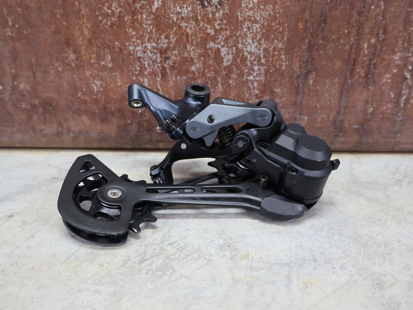 Schaltungsteile von Shimano, SHIMANO SLX RD - M7100 - SGS SCHALTWERK 12 FACH vor USEDBIKES - OB.DE Hintergrund