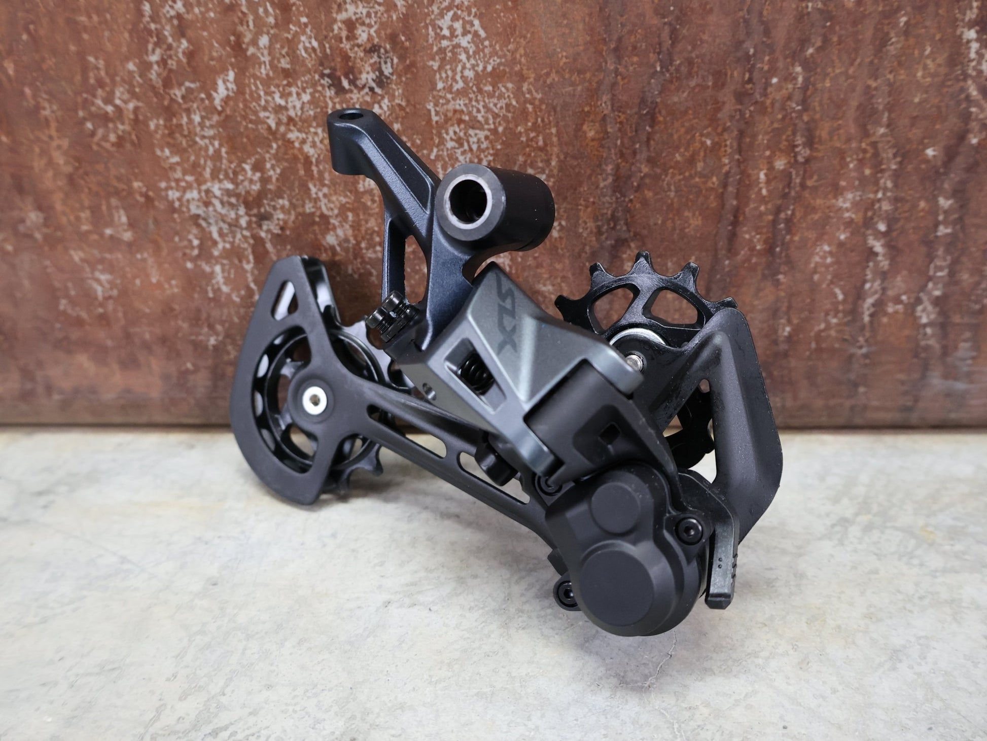 Schaltungsteile von Shimano, SHIMANO SLX RD - M7100 - SGS SCHALTWERK 12 FACH vor USEDBIKES - OB.DE Hintergrund