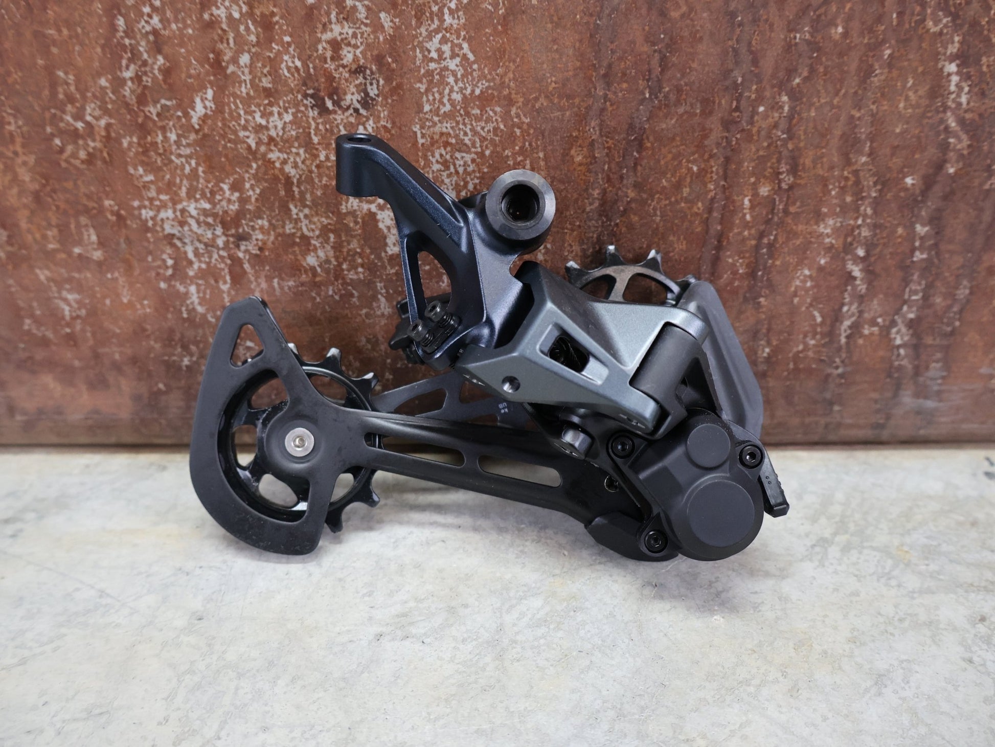 Schaltungsteile von Shimano, SHIMANO SLX RD - M7100 - SGS SCHALTWERK 12 FACH vor USEDBIKES - OB.DE Hintergrund