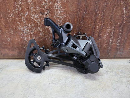 Schaltungsteile von Shimano, SHIMANO SLX RD - M7100 - SGS SCHALTWERK 12 FACH vor USEDBIKES - OB.DE Hintergrund