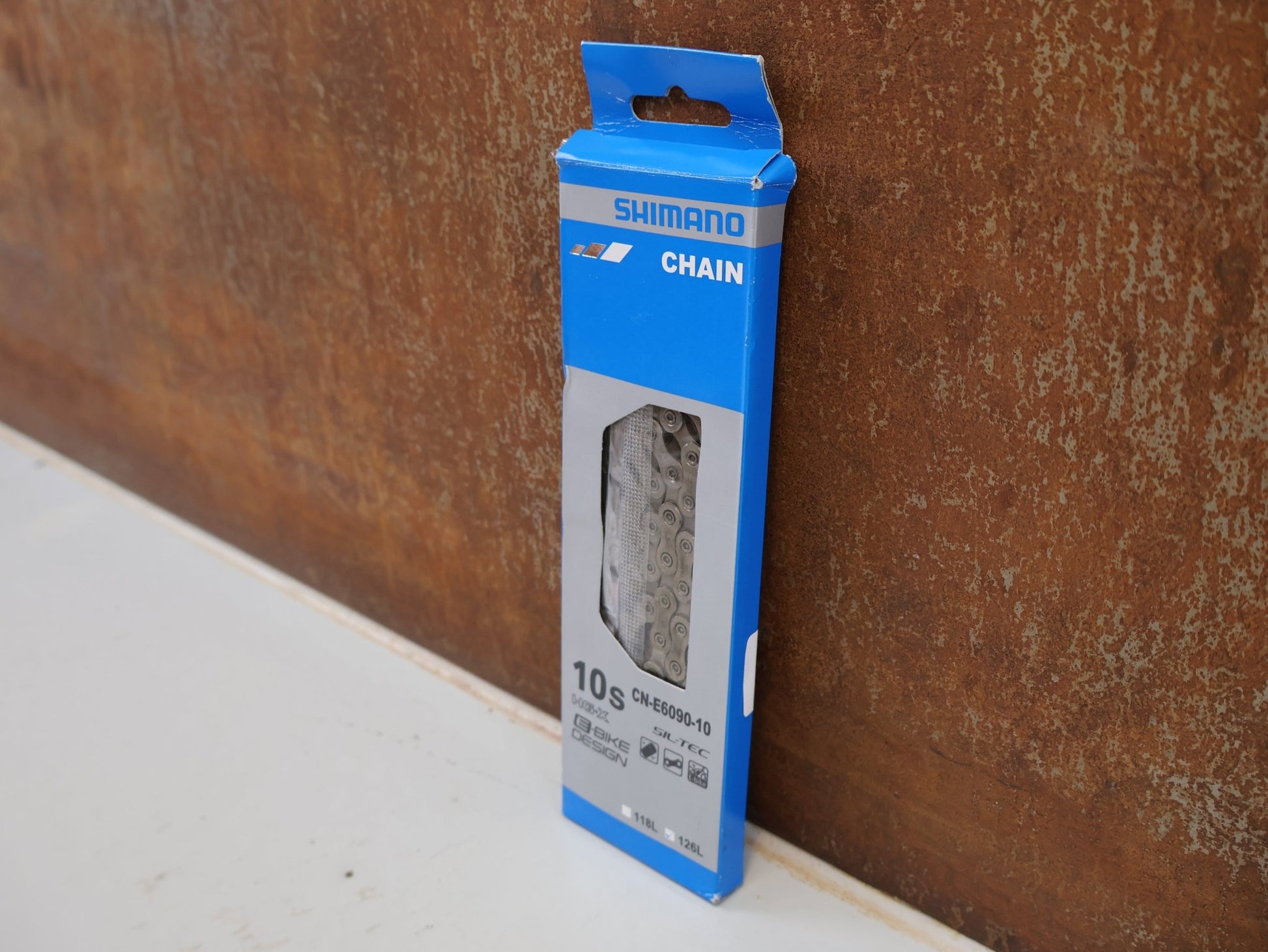 Kette von Shimano, SHIMANO STEPS CN-E6090-10 KETTE / 10-FACH 126 GLIEDER E-BIKE HG-X SIL-TEC vor USEDBIKES-OB.DE Hintergrund