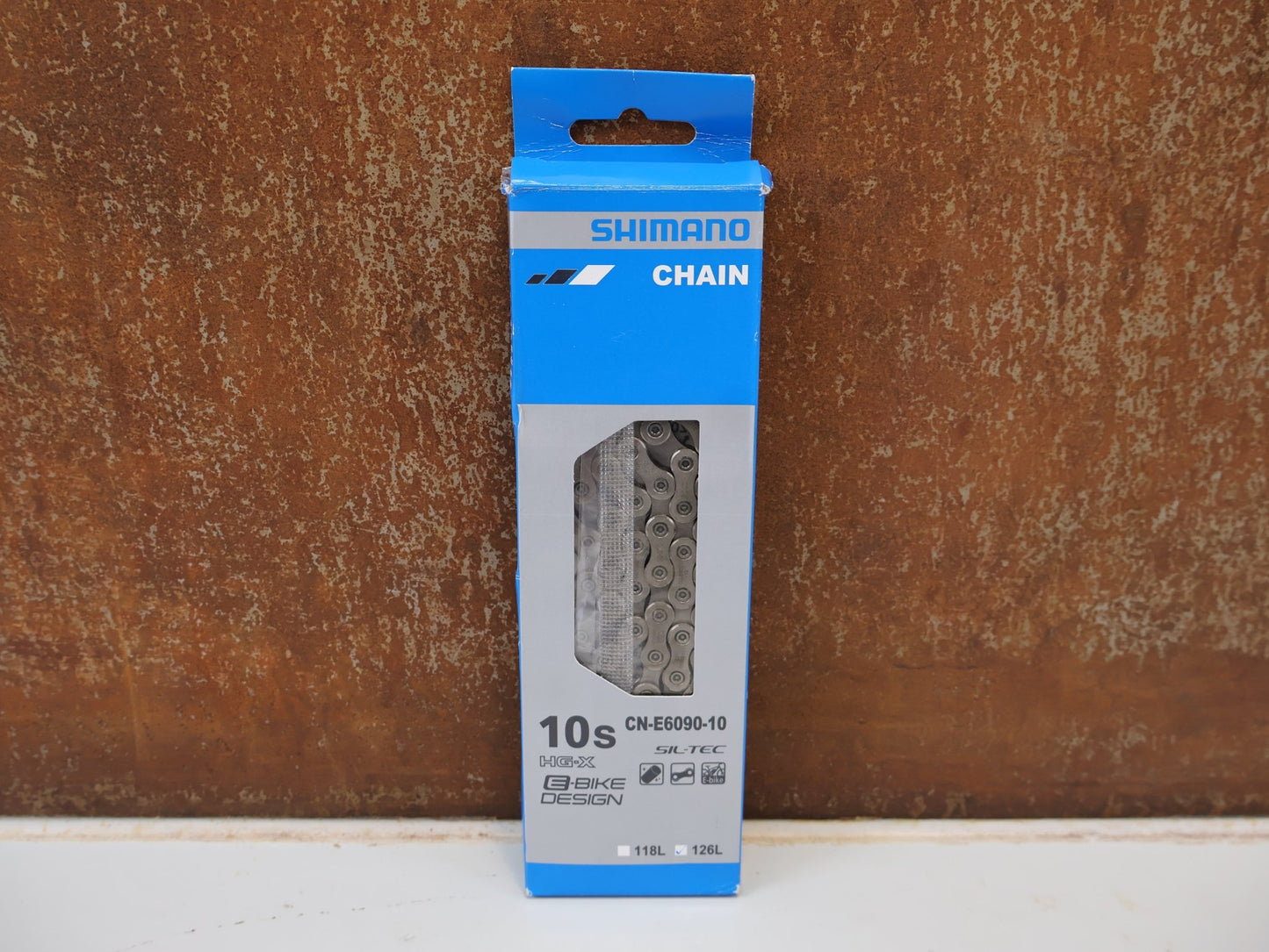Kette von Shimano, SHIMANO STEPS CN-E6090-10 KETTE / 10-FACH 126 GLIEDER E-BIKE HG-X SIL-TEC vor USEDBIKES-OB.DE Hintergrund