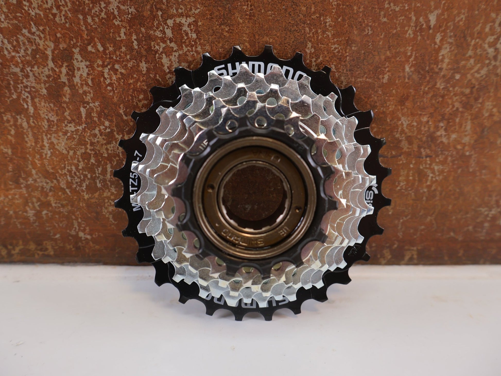Kassette & Zahnkränze von Shimano, SHIMANO TOURNEY MF - TZ510 FREILAUFZAHNKRANZ / 7 - FACH / 14 - 28Z / SCHRAUBKRANZ / EMFTZ5107428 vor USEDBIKES - OB.DE Hintergrund