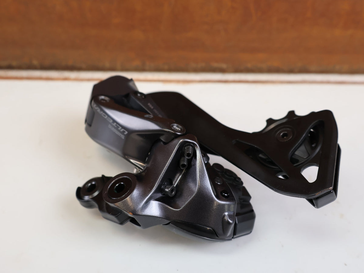 Schaltungsteile von Shimano, SHIMANO ULTEGRA DI2 RD R8150 SCHALTWERK 12 FACH 34Z DIRECT MOUNT vor USEDBIKES-OB.DE Hintergrund