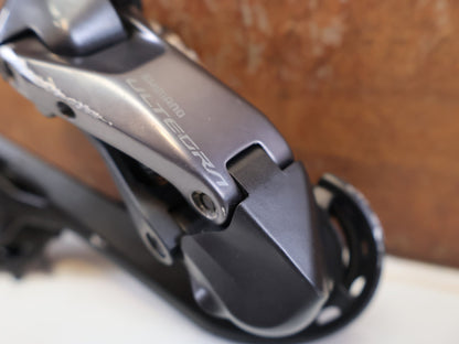 Schaltungsteile von Shimano, SHIMANO ULTEGRA DI2 RD-R8150 SCHALTWERK 2 x 12 FACH vor USEDBIKES-OB.DE Hintergrund
