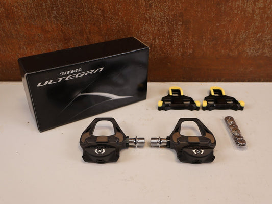 Pedale von Shimano, SHIMANO ULTEGRA PD R8000 CARBON SPD SL PEDALE RENNRAD vor USEDBIKES-OB.DE Hintergrund