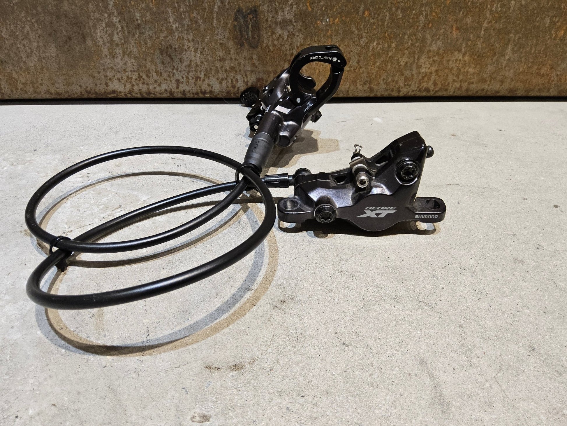 Bremse von Shimano, SHIMANO XT BL - M8100 / BR - M8100 2 KOLBEN SCHEIBENBREMSE SET vor USEDBIKES - OB.DE Hintergrund