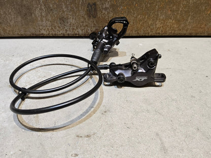 Bremse von Shimano, SHIMANO XT BL - M8100 / BR - M8100 2 KOLBEN SCHEIBENBREMSE SET vor USEDBIKES - OB.DE Hintergrund