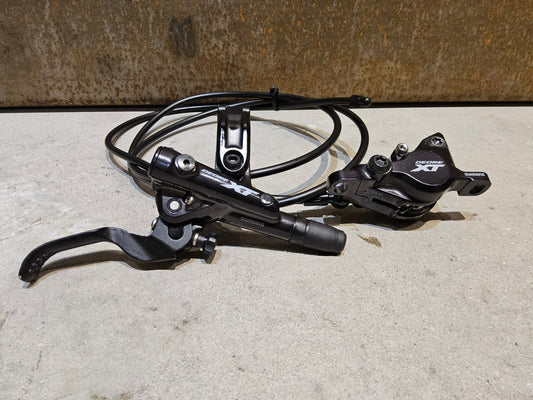 Bremse von Shimano, SHIMANO XT BL - M8100 / BR - M8100 2 KOLBEN SCHEIBENBREMSE SET vor USEDBIKES - OB.DE Hintergrund