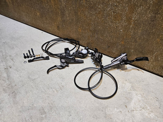 Bremse von Shimano, SHIMANO XT BL - M8100 / BR - M8100 2 KOLBEN SCHEIBENBREMSE SET vor USEDBIKES - OB.DE Hintergrund