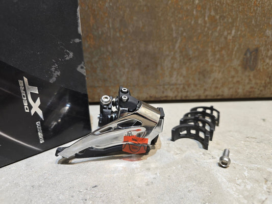 Schaltungsteile von Shimano, SHIMANO XT FD - M8025 - L UMWERFER 2 X 11 FACH / SCHELLE in variant_title vor USEDBIKES - OB.DE Hintergrund