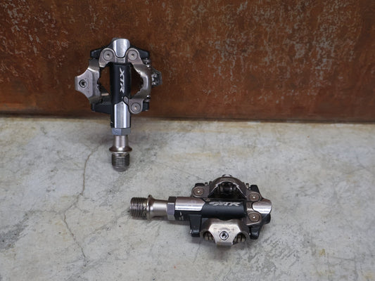 Pedale von Shimano, SHIMANO XTR PD - M9100 SPD / MOUNTAINBIKE PEDAL vor USEDBIKES - OB.DE Hintergrund