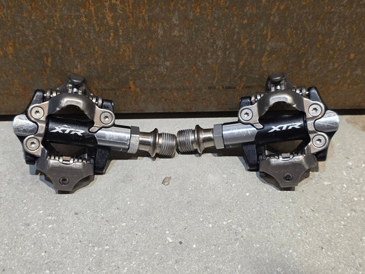 Pedale von Shimano, SHIMANO XTR PD - M9100 SPD / MOUNTAINBIKE PEDAL vor USEDBIKES - OB.DE Hintergrund
