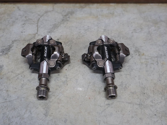 Pedale von Shimano, SHIMANO XTR PD - M9100 SPD / MOUNTAINBIKE PEDAL vor USEDBIKES - OB.DE Hintergrund