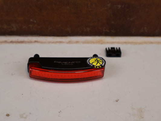 Beleuchtung von Spanninga, SPANNINGA PIMENTO XDVS DYNAMO RÜCKLICHT 50MM LED GEPÄCKTRÄGER vor USEDBIKES-OB.DE Hintergrund