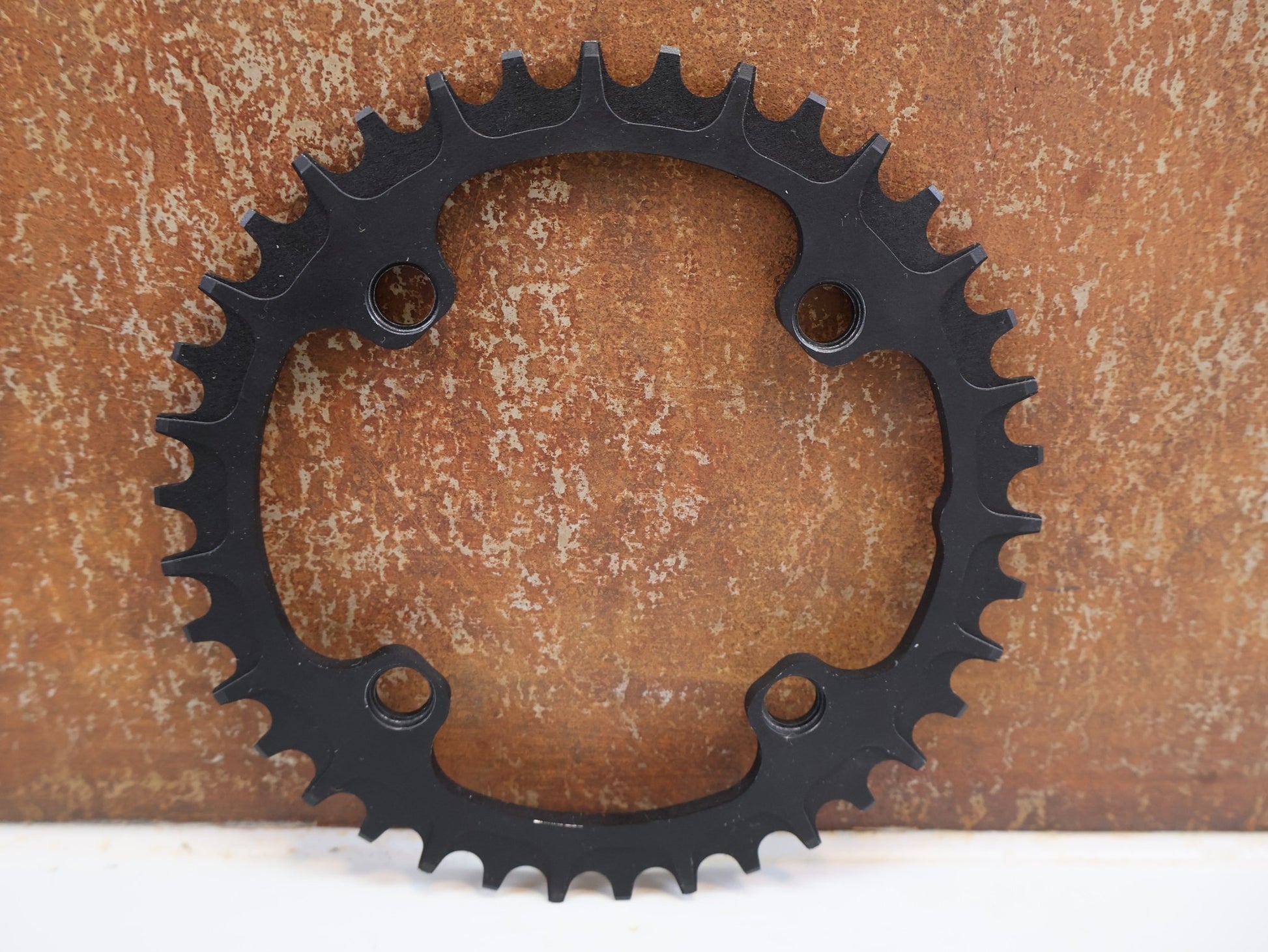 Kettenblatt von Specialites T.A., SPECIALITES T.A. KETTENBLATT ONE 104 / 38 ZÄHNE / 10-11-12-FACH vor USEDBIKES-OB.DE Hintergrund
