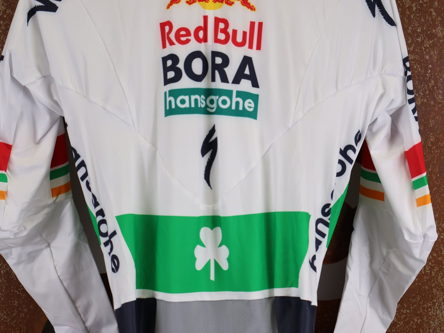 Anzug - BOH von Specialized, SPECIALIZED RED BULL - BORA HANSGROHE AERO SKIN SUIT LS / IRISH CHAMPION vor USEDBIKES - OB.DE Hintergrund