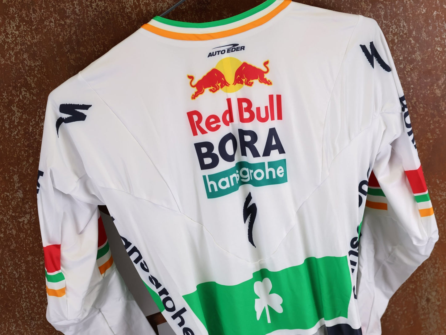 Anzug - BOH von Specialized, SPECIALIZED RED BULL - BORA HANSGROHE AERO SKIN SUIT LS / IRISH CHAMPION vor USEDBIKES - OB.DE Hintergrund