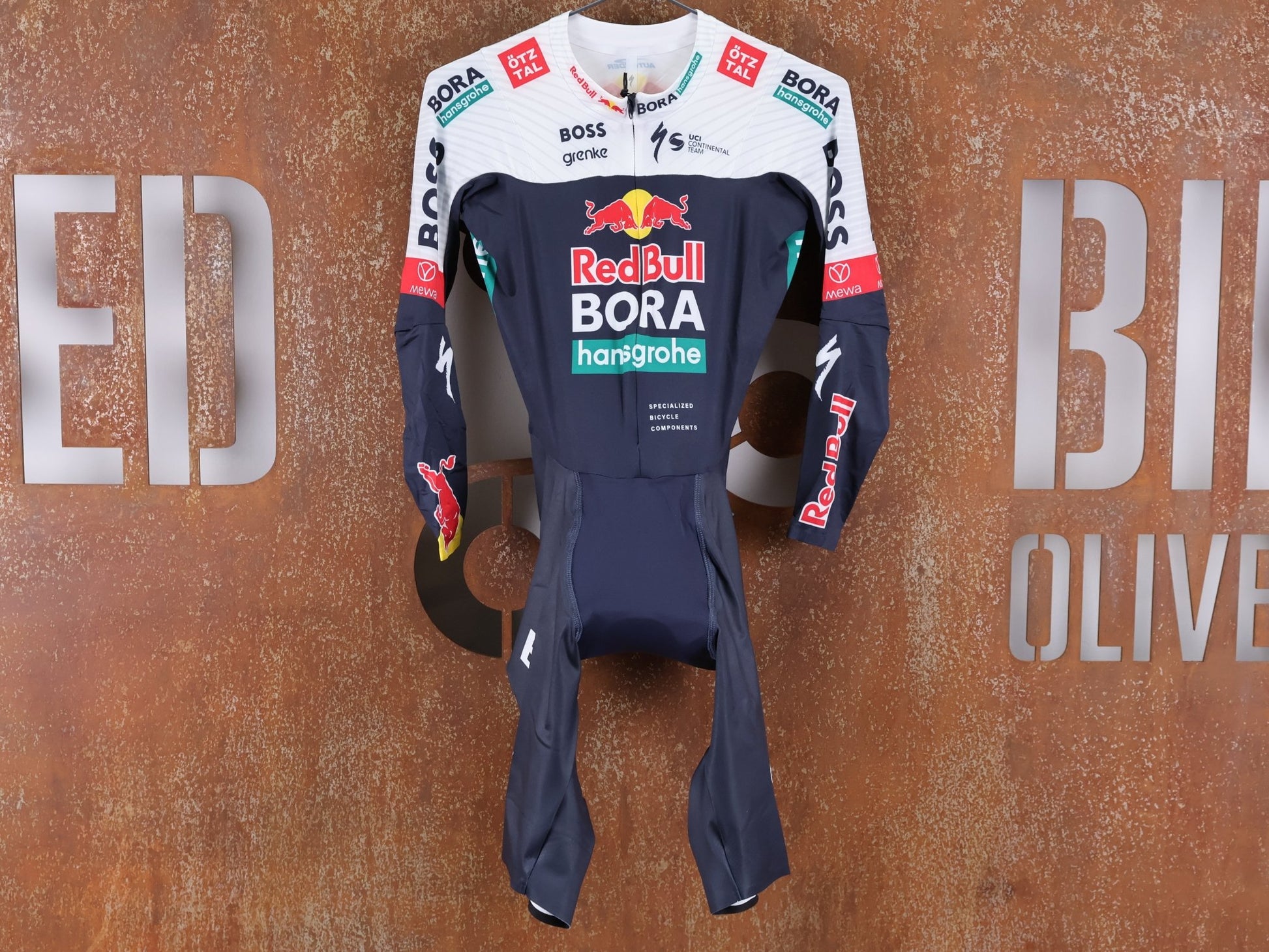 Anzug - BOH von Specialized, SPECIALIZED RED BULL - BORA HANSGROHE AERO SKIN SUIT LS / LANGARM EINTEILER U23 vor USEDBIKES - OB.DE Hintergrund