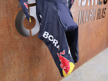 Anzug - BOH von Specialized, SPECIALIZED RED BULL - BORA HANSGROHE AERO SKIN SUIT LS / LANGARM EINTEILER U23 vor USEDBIKES - OB.DE Hintergrund