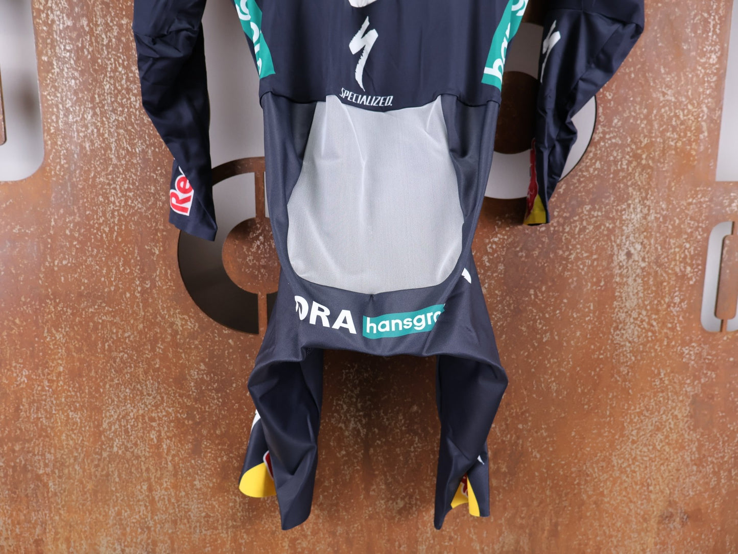 Anzug - BOH von Specialized, SPECIALIZED RED BULL - BORA HANSGROHE AERO SKIN SUIT LS / LANGARM EINTEILER U23 vor USEDBIKES - OB.DE Hintergrund