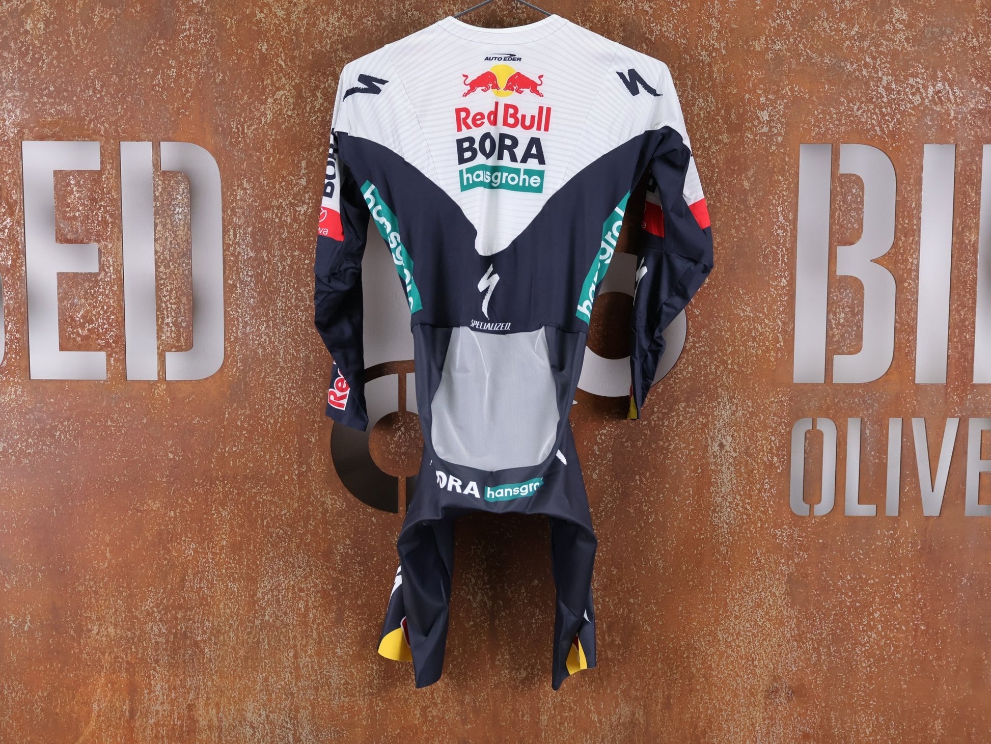 Anzug - BOH von Specialized, SPECIALIZED RED BULL - BORA HANSGROHE AERO SKIN SUIT LS / LANGARM EINTEILER U23 vor USEDBIKES - OB.DE Hintergrund