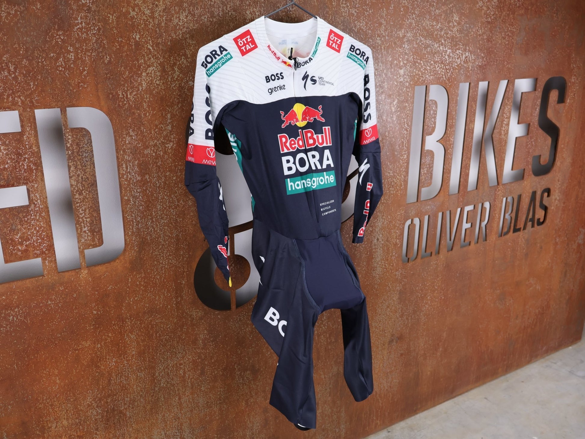 Anzug - BOH von Specialized, SPECIALIZED RED BULL - BORA HANSGROHE AERO SKIN SUIT LS / LANGARM EINTEILER U23 vor USEDBIKES - OB.DE Hintergrund