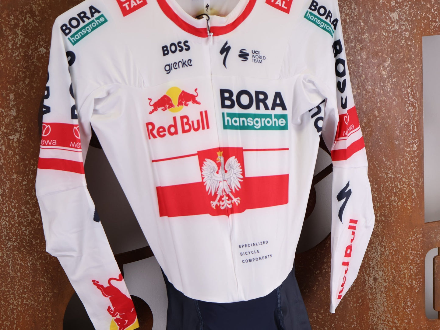 Anzug - BOH von Specialized, SPECIALIZED RED BULL - BORA HANSGROHE AERO SKIN SUIT LS / POLAND CHAMPION vor USEDBIKES - OB.DE Hintergrund