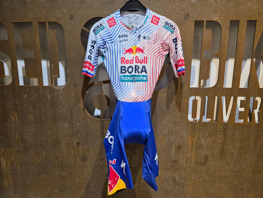 Anzug - BOH von Specialized, SPECIALIZED RED BULL - BORA HANSGROHE AERO SKIN SUIT SS / EINTEILER ROGLIC vor USEDBIKES - OB.DE Hintergrund