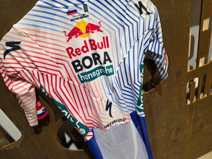 Anzug - BOH von Specialized, SPECIALIZED RED BULL - BORA HANSGROHE AERO SKIN SUIT SS / EINTEILER ROGLIC vor USEDBIKES - OB.DE Hintergrund