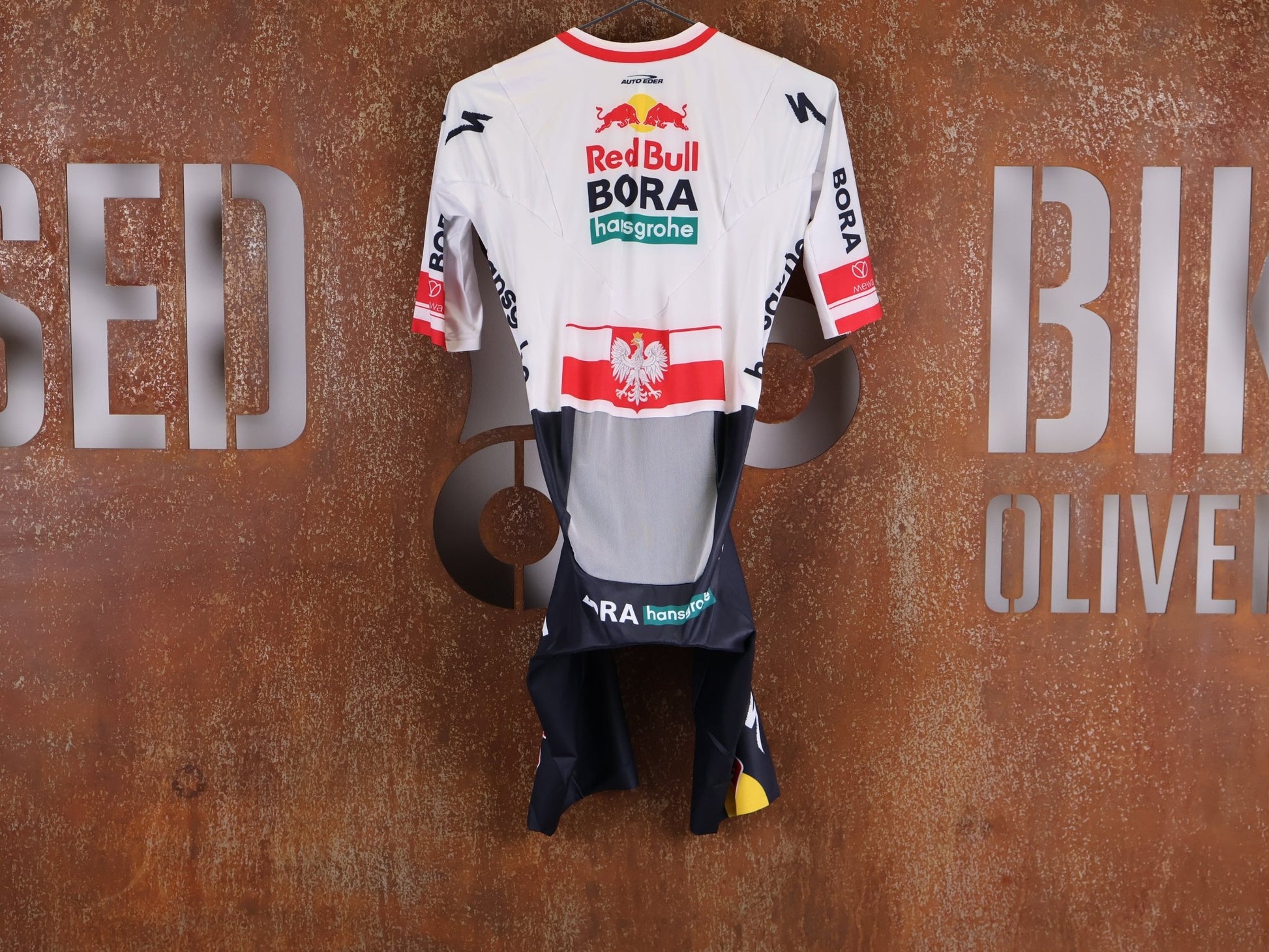 Anzug - BOH von Specialized, SPECIALIZED RED BULL - BORA HANSGROHE AERO SKIN SUIT SS / POLAND CHAMPION vor USEDBIKES - OB.DE Hintergrund