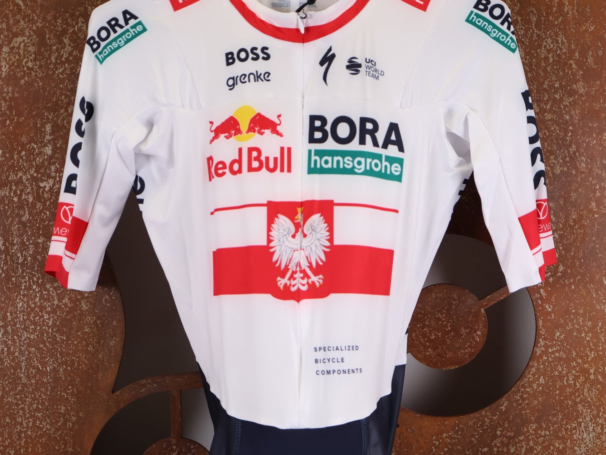 Anzug - BOH von Specialized, SPECIALIZED RED BULL - BORA HANSGROHE AERO SKIN SUIT SS / POLAND CHAMPION vor USEDBIKES - OB.DE Hintergrund