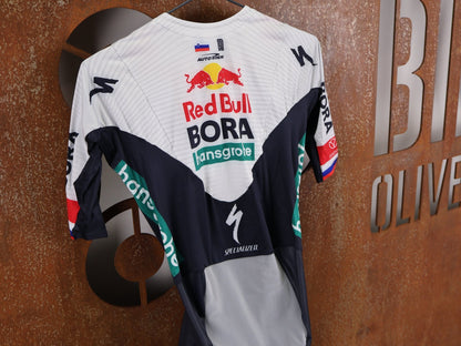 Anzug - BOH von Specialized, SPECIALIZED RED BULL - BORA HANSGROHE AERO SKIN SUIT SS ROGLIČ / KURZARM EINTEILER vor USEDBIKES - OB.DE Hintergrund