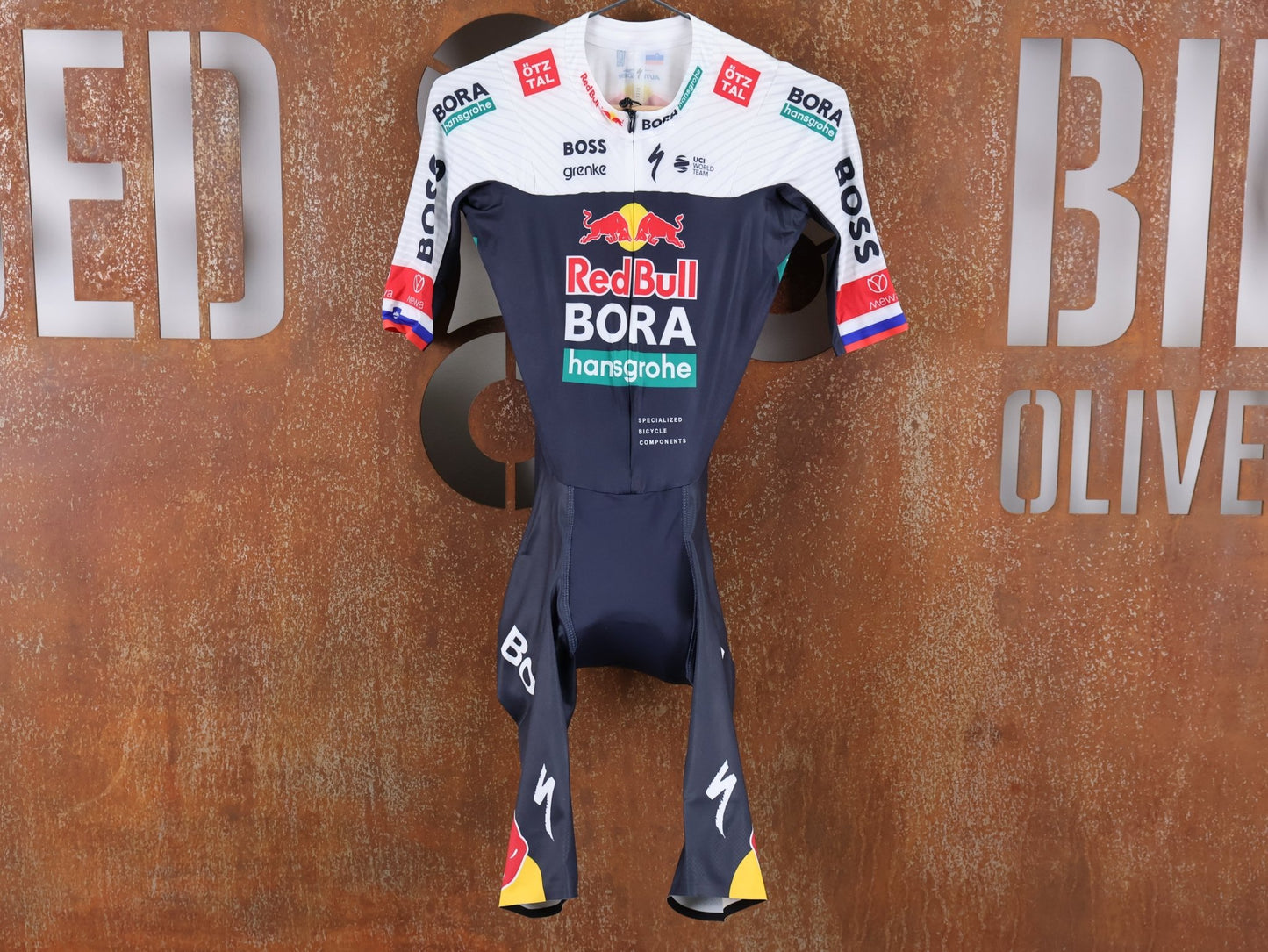Anzug - BOH von Specialized, SPECIALIZED RED BULL - BORA HANSGROHE AERO SKIN SUIT SS ROGLIČ / KURZARM EINTEILER vor USEDBIKES - OB.DE Hintergrund