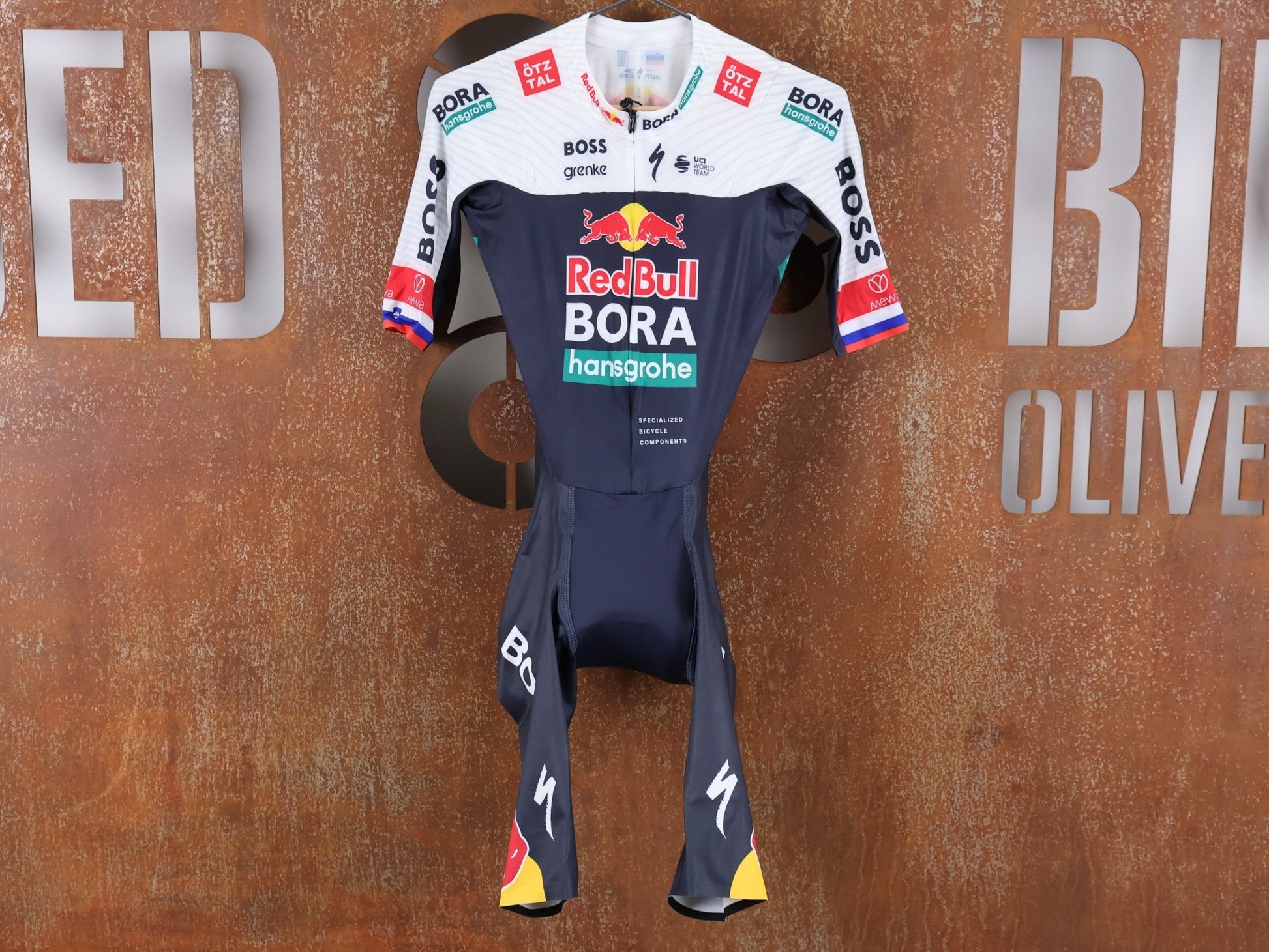 Anzug - BOH von Specialized, SPECIALIZED RED BULL - BORA HANSGROHE AERO SKIN SUIT SS ROGLIČ / KURZARM EINTEILER vor USEDBIKES - OB.DE Hintergrund