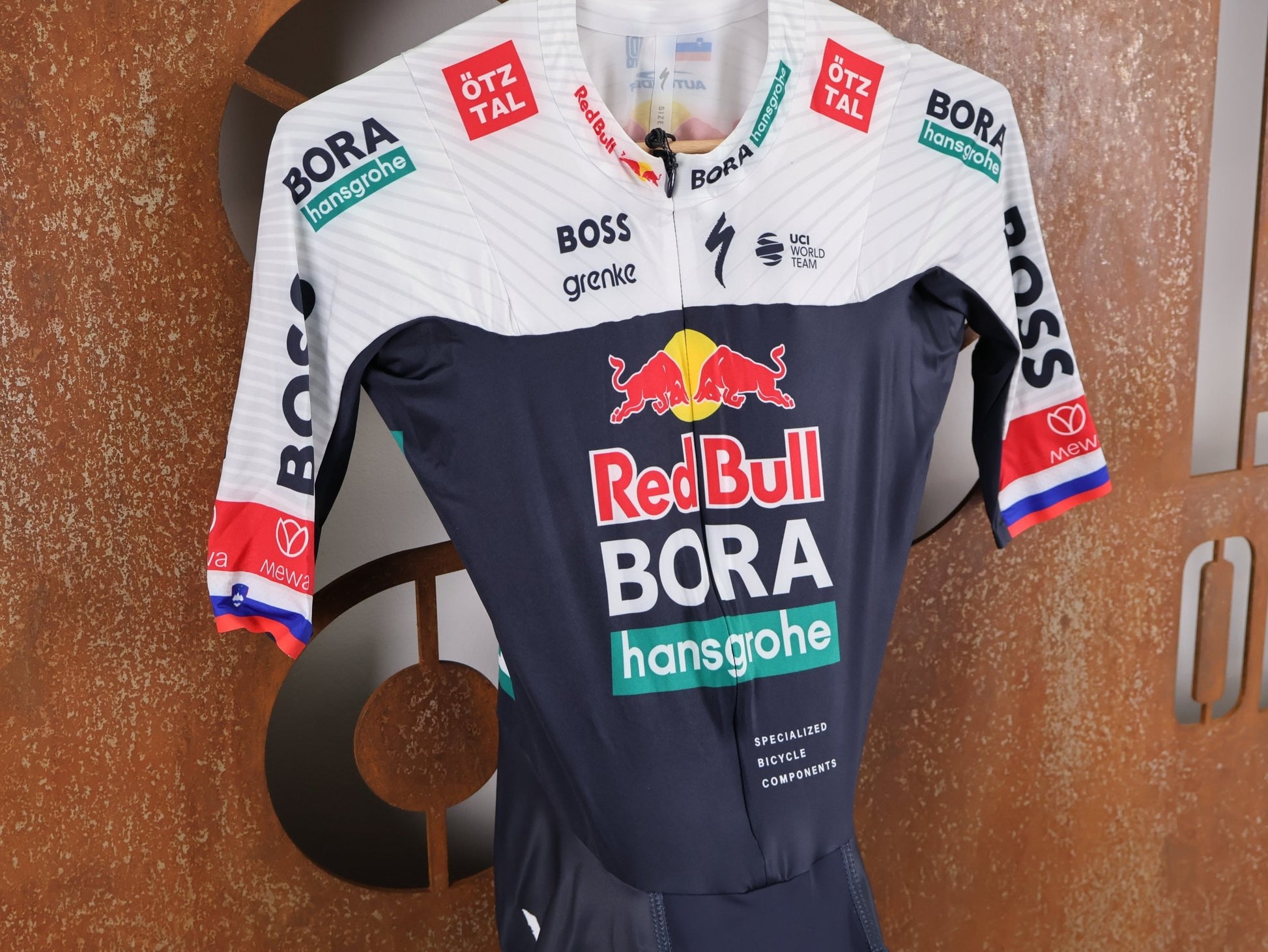 Anzug - BOH von Specialized, SPECIALIZED RED BULL - BORA HANSGROHE AERO SKIN SUIT SS ROGLIČ / KURZARM EINTEILER vor USEDBIKES - OB.DE Hintergrund