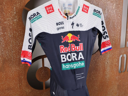 Anzug - BOH von Specialized, SPECIALIZED RED BULL - BORA HANSGROHE AERO SKIN SUIT SS ROGLIČ / KURZARM EINTEILER vor USEDBIKES - OB.DE Hintergrund