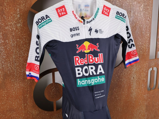 Anzug - BOH von Specialized, SPECIALIZED RED BULL - BORA HANSGROHE AERO SKIN SUIT SS ROGLIČ / KURZARM EINTEILER vor USEDBIKES - OB.DE Hintergrund