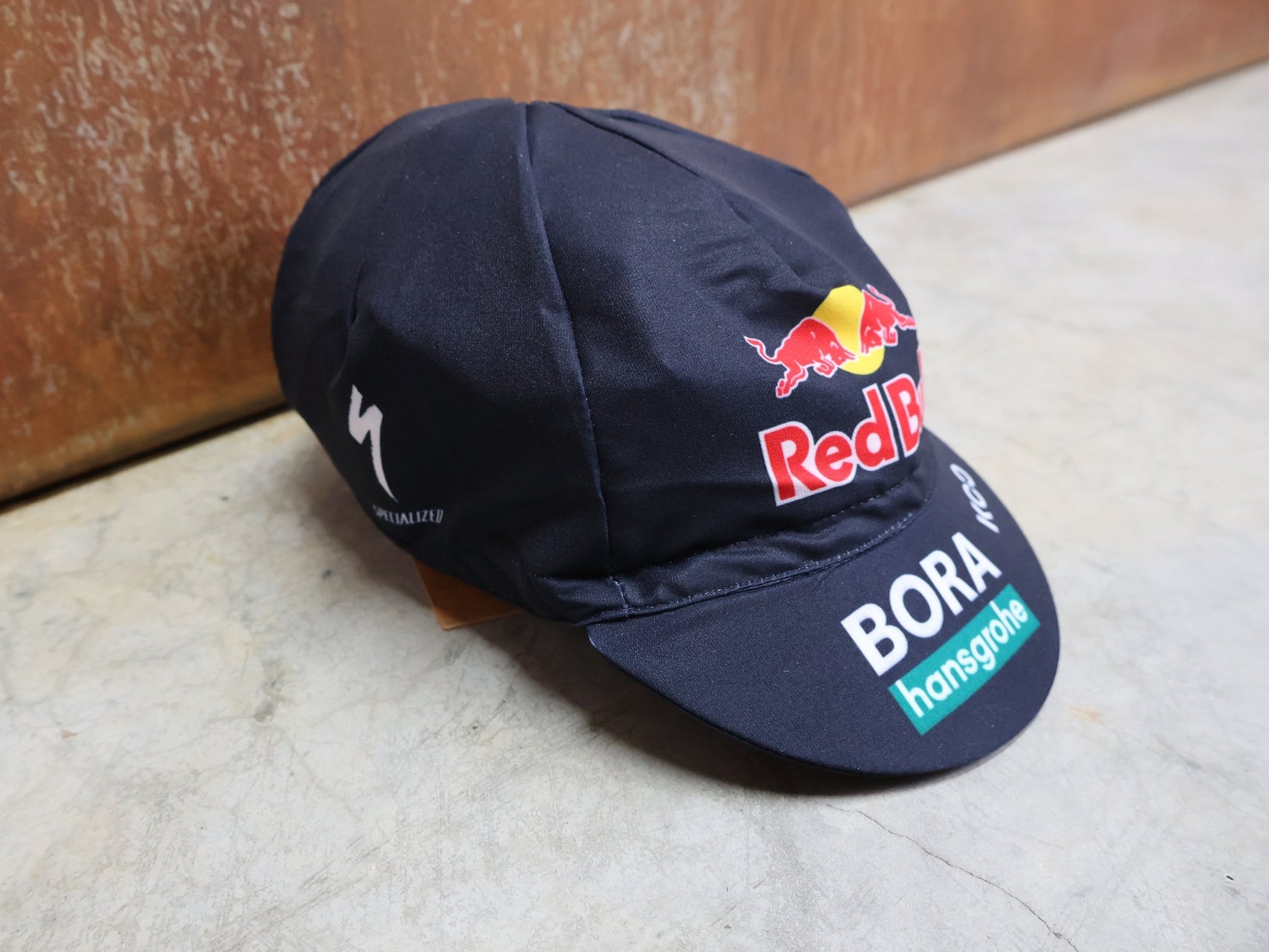 Caps - BOH von Specialized, SPECIALIZED RED BULL - BORA HANSGROHE CYCLING CAP / MÜTZE vor USEDBIKES - OB.DE Hintergrund