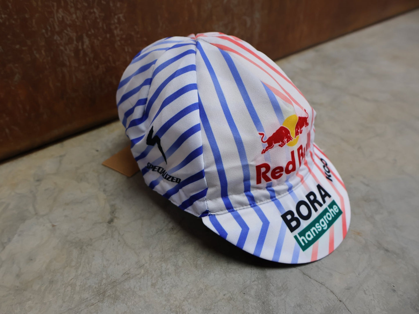 Caps - BOH von Specialized, SPECIALIZED RED BULL - BORA HANSGROHE CYCLING CAP TDF / MÜTZE vor USEDBIKES - OB.DE Hintergrund