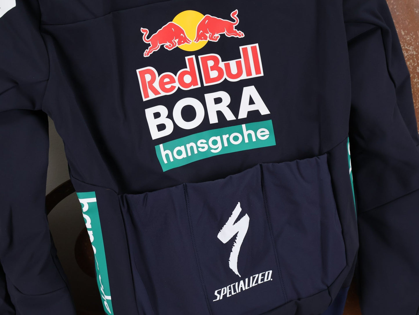Langarm Trikot - BOH von Specialized, SPECIALIZED RED BULL - BORA HANSGROHE INSULATED SOFTSHELL JACKET / WINTERJACKE vor USEDBIKES - OB.DE Hintergrund