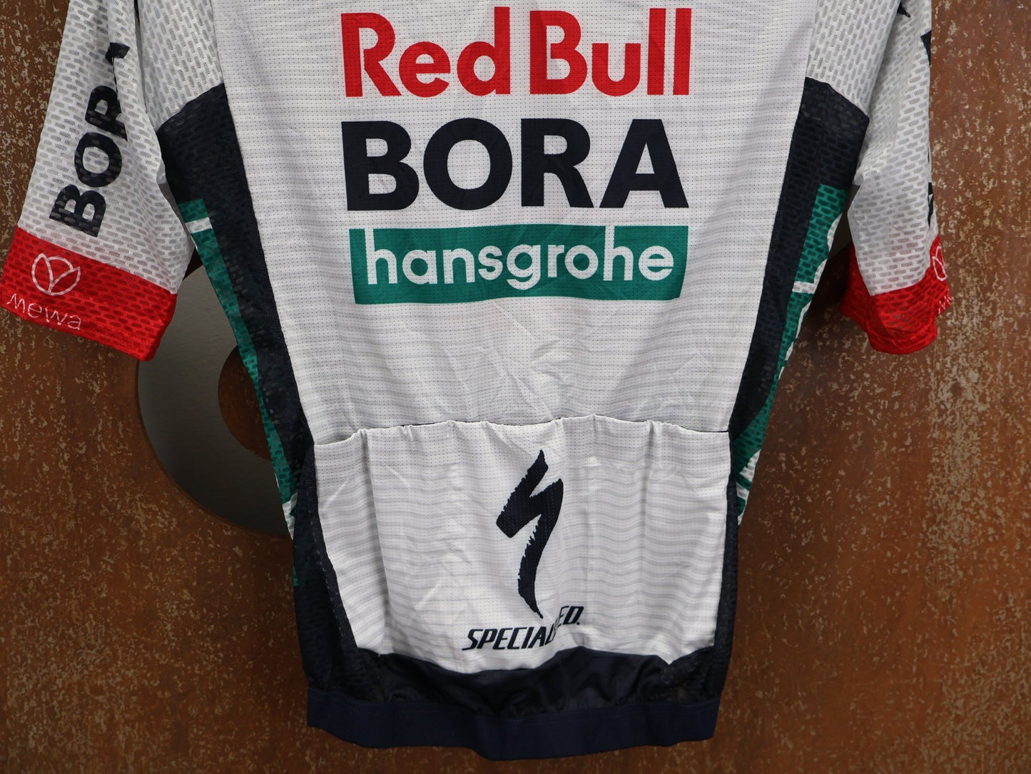 Kurzarm Trikot - BOH von Specialized, SPECIALIZED RED BULL - BORA HANSGROHE LIGHTWEIGHT JERSEY SS / KURZARM TRIKOT U23 vor USEDBIKES - OB.DE Hintergrund