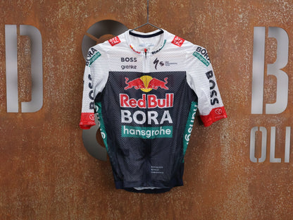 Kurzarm Trikot - BOH von Specialized, SPECIALIZED RED BULL - BORA HANSGROHE LIGHTWEIGHT JERSEY SS / KURZARM TRIKOT U23 vor USEDBIKES - OB.DE Hintergrund